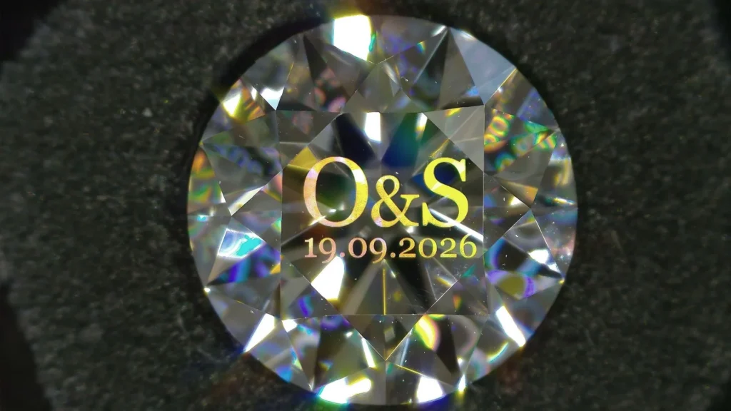 Diamond personalized with initials and date using Arteida femtosecond laser structuring. "O&S 19.09.2026" on the diamond's surface
